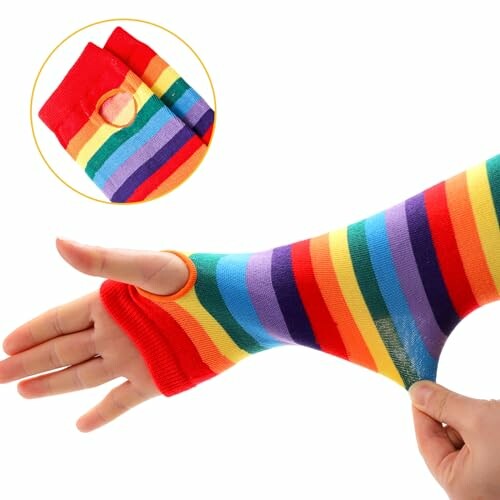 Hand wearing a rainbow-striped arm warmer with thumb hole.