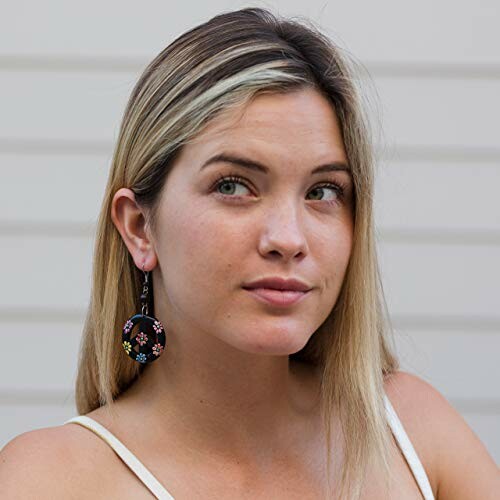 Woman wearing colorful floral earrings.